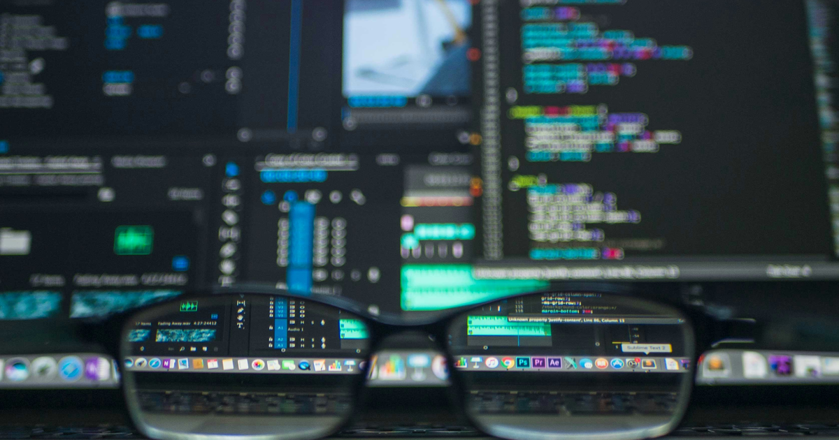 Developer coding workspace viewed through glasses