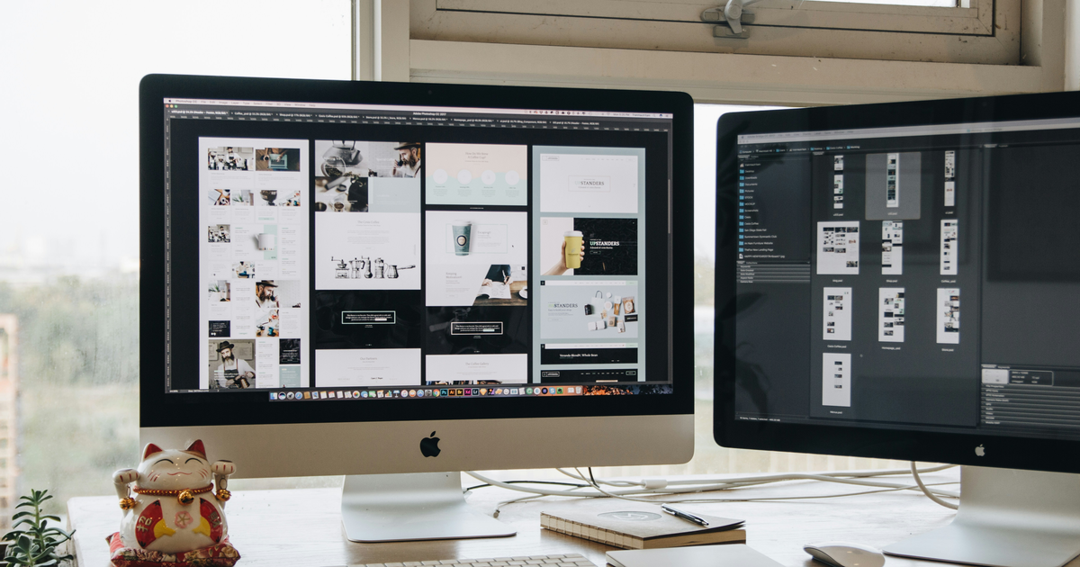 Web designer working across desktop screens
